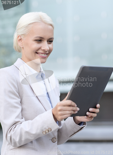 Image of smiling businesswoman with tablet pc outdoors