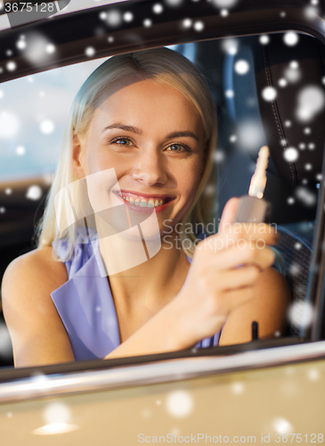 Image of happy woman getting car key in auto show or salon