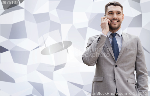 Image of smiling businessman with smartphone outdoors