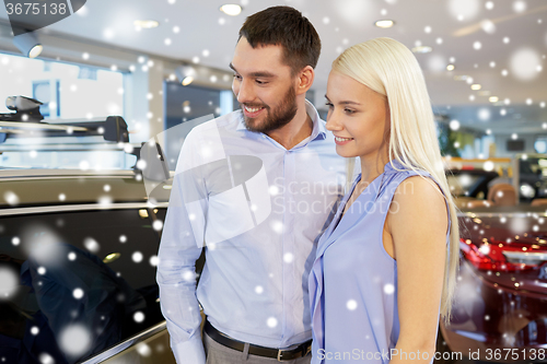 Image of happy couple buying car in auto show or salon