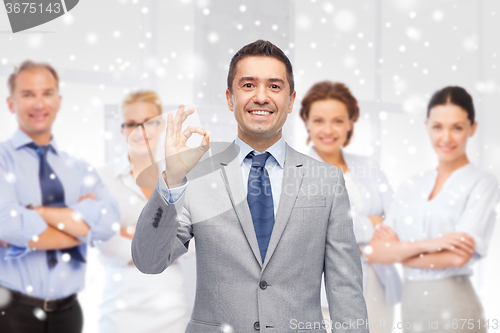 Image of happy businessman in suit showing ok hand sign