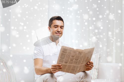 Image of happy man reading newspaper at home