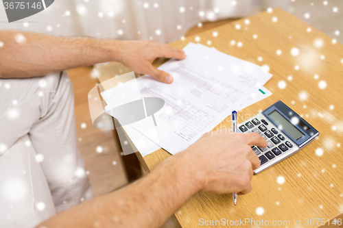 Image of close up of man with papers and calculator at home