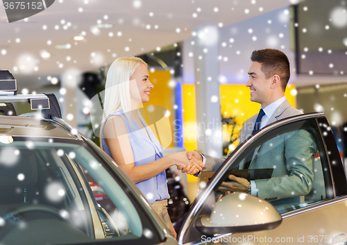 Image of happy woman with car dealer in auto show or salon