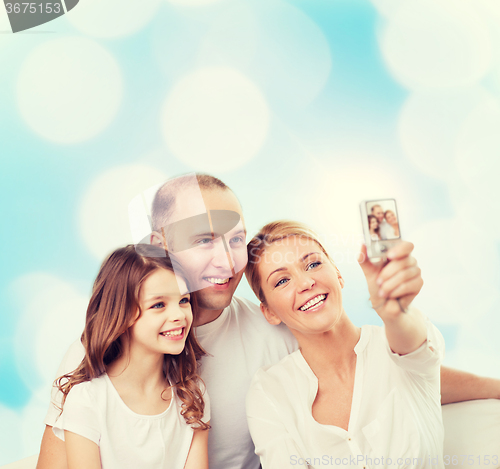 Image of happy family with camera at home