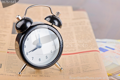 Image of Close-up of clock, Euro banknotes and newspaper