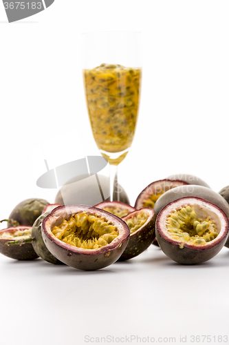 Image of Halved Passionfruits And Fruit Pulp In A Glass