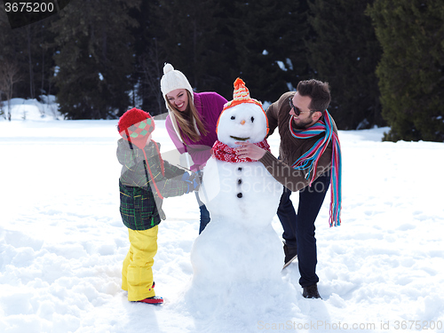 Image of happy family making snowman