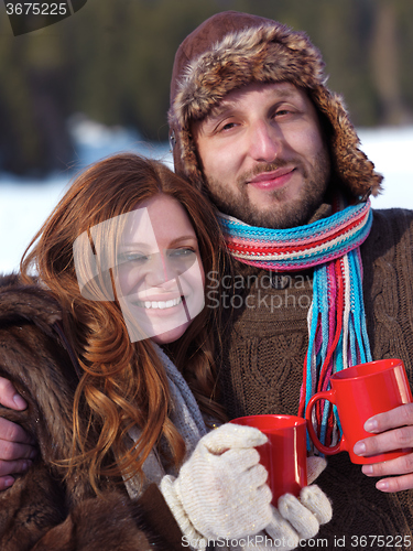 Image of happy young couple drink warm tea at winter