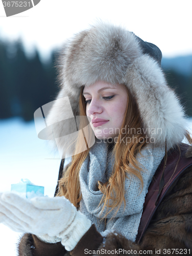 Image of portrait of  girl with gift at winter scene and snow in backgron