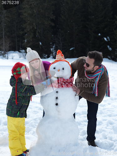 Image of happy family making snowman