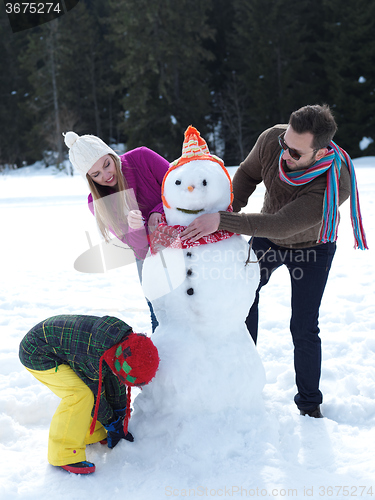 Image of happy family making snowman