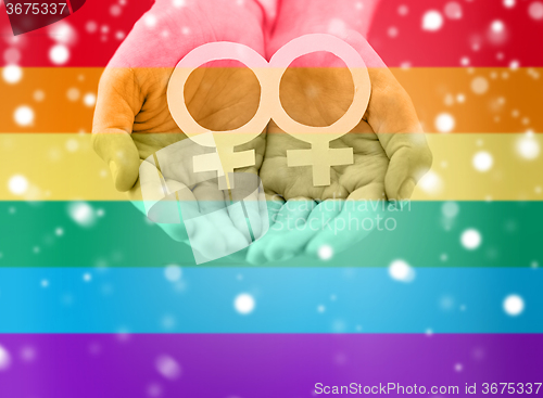 Image of close up of lesbian couple hands with venus symbol