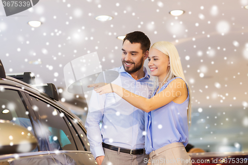 Image of happy couple buying car in auto show or salon