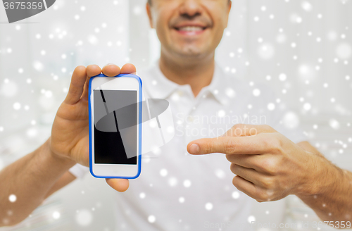 Image of close up of happy man with smartphone at home