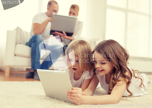 Image of smiling sister with tablet pc and parents on back