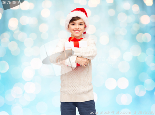 Image of smiling happy boy in santa hat with gift box