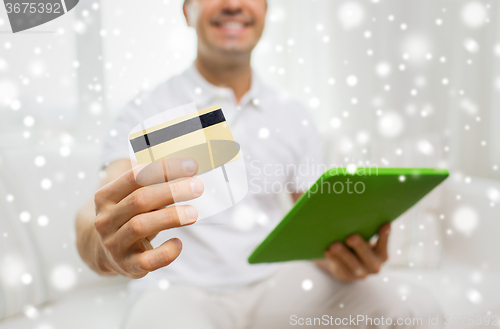 Image of close up of man with credit card and tablet pc