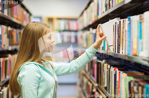Image of happy student girl or woman with book in library
