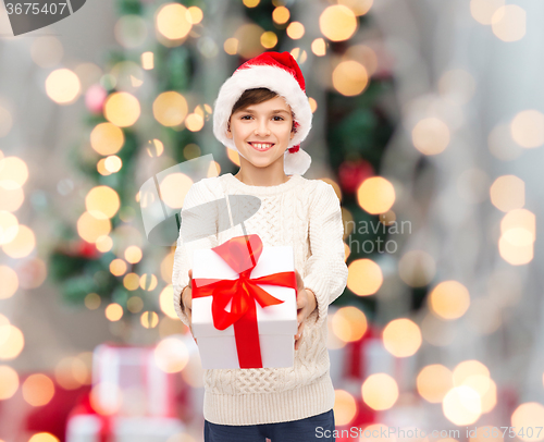 Image of smiling happy boy in santa hat with gift box