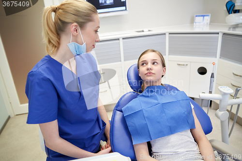 Image of happy female dentist with patient girl at clinic