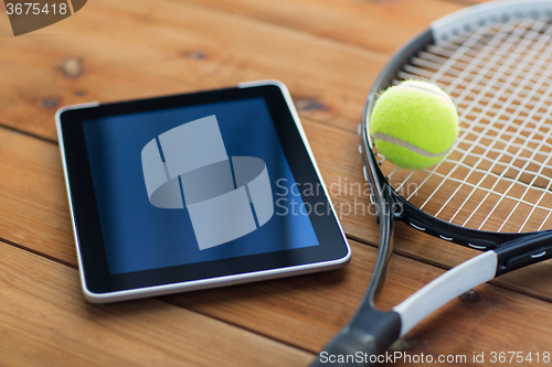 Image of close up of tennis racket with ball and tablet pc