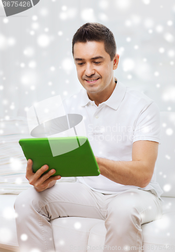 Image of smiling man working with tablet pc at home