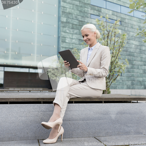 Image of smiling businesswoman with tablet pc outdoors