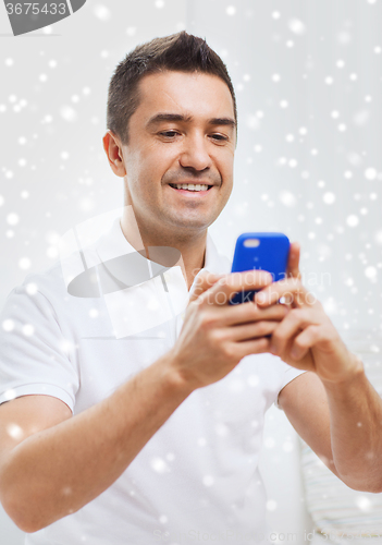 Image of happy man with smartphone at home