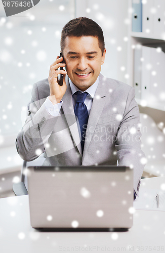 Image of smiling businessman with laptop and smartphone