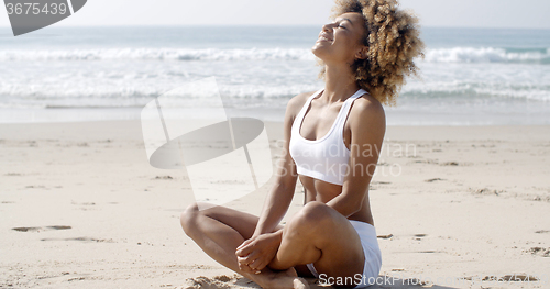 Image of Woman Meditating On Beach In Lotus Position