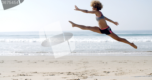Image of Happy Young Woman Jumping On The Beach