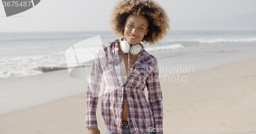 Image of Girl With Headphones Walking On The Beach