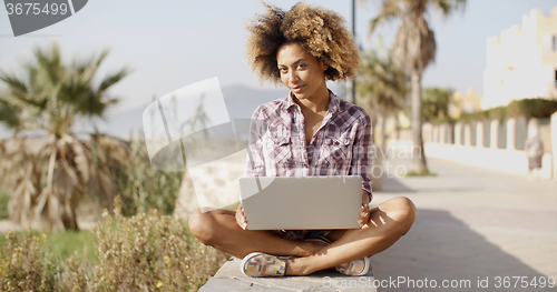 Image of Girl Browsing A Laptop In A Bench