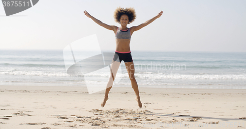 Image of Fit Woman Jumping On The Beach