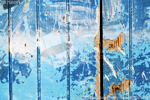 Image of stripped  in the blue   door and rusty nail