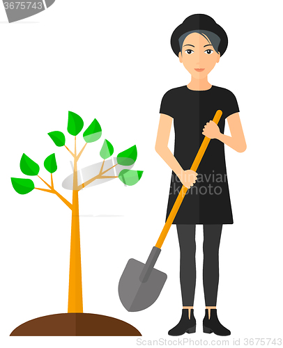 Image of Woman plants tree.