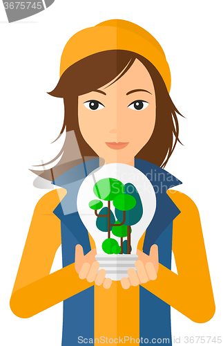 Image of Woman with lightbulb and trees inside.