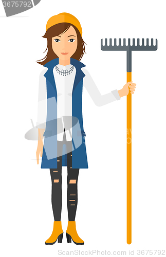 Image of Woman standing with rake.