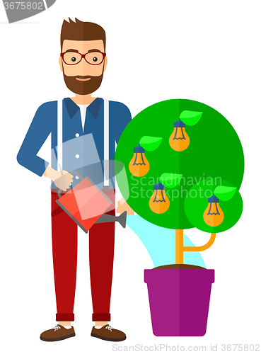 Image of Man watering tree with light bulbs.