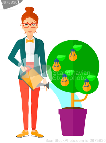 Image of Woman watering tree with light bulbs.