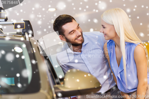 Image of happy couple buying car in auto show or salon