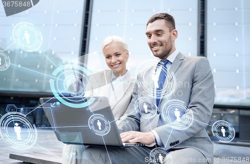 Image of smiling businesspeople with laptop outdoors