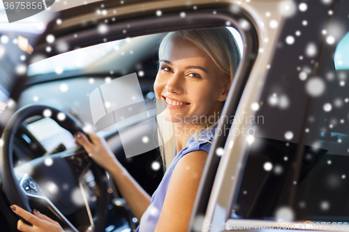 Image of happy woman inside car in auto show or salon