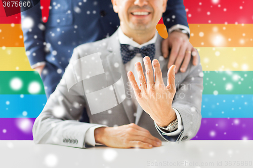 Image of close up of male gay couple with wedding rings on