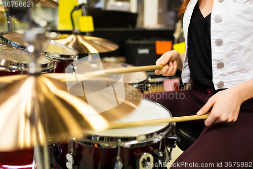 Image of close up of woman playing cymbals at music store