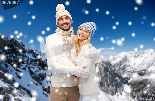 Image of couple in winter clothes over snowy mountains