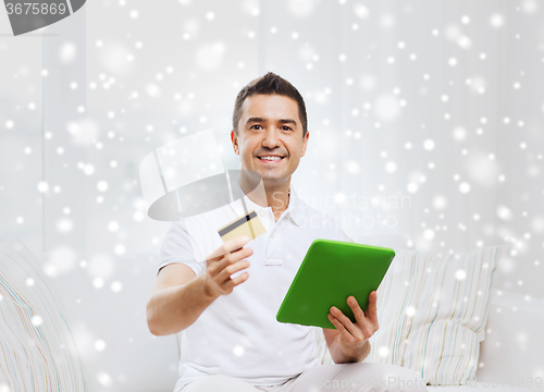 Image of smiling man working with tablet pc at home