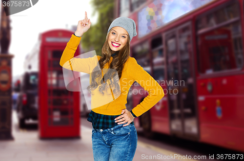 Image of happy young woman or teen girl pointing finger up