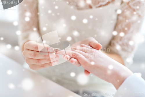 Image of close up of lesbian couple hands with wedding ring